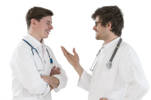 Zwei Ärzte Männer im Gespräch und einer von ihnen hat verschränkte Arme weißen Hintergrund — Stockfoto