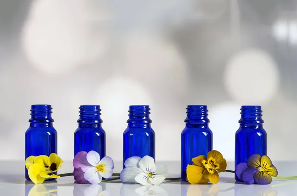 Viola tricolor nice pansies,essential oil in bottle — Stock Image Viola tricolor nice pansies,essential oil in bottle Royalty Free Stock Images