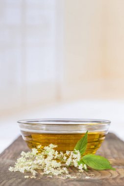bir bowlof elderflower çay ile bir fışkın taze çiçekler ve yapraklar
