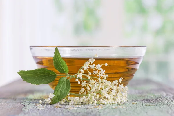 bir bowlof elderflower çay ile bir fışkın taze çiçekler ve yapraklar