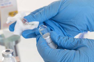 Hemşire el veya doktor enjeksiyon için ilaç şişesi. Aşı için tıbbi cam şişe.
