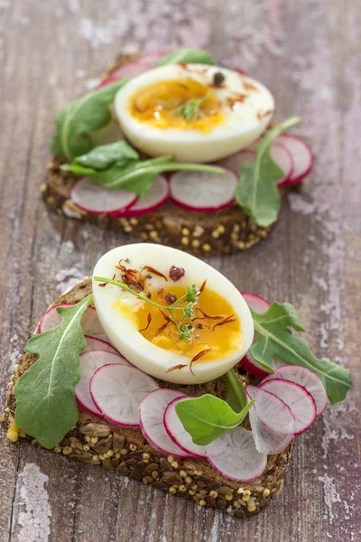 Roka, turp ve eggswooden arka plan ile bir içten kepekli sandviç