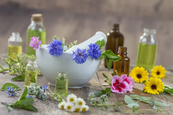 Ätherische Öle zur Aromatherapie mit frischen Kräutern im weißen Mörser-Hintergrund — Stockfoto