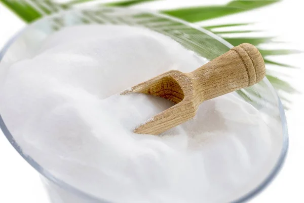 Vue du dessus du bol de bicarbonate de soude avec, en bois, cuillère sur fond blanc avec feuilles vertes — Photo