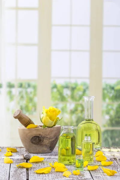 Žluté růže květiny na dřevěném hmoždíři pro bylinné medicíny na pozadí windows — Stock fotografie