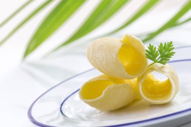 Tereyağı curl veya arka planda açık view.greenery plaka üzerinde rulo