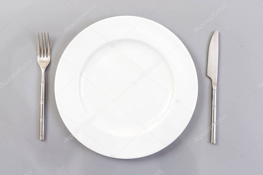 Empty Round Plate with Fork and Knife Top View Isolated on slate Background. Table Setting