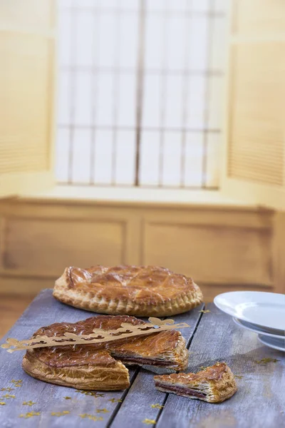 Galette des Rois gâteau. Gâteau traditionnel à l'épiphanie française avec amande sur panneau de bois gris sur fond de fenêtre . — Photo