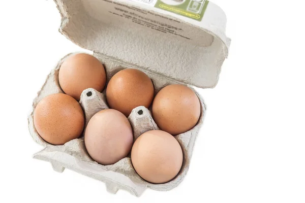 Close-up shot van een open recycleerbaar ei karton met zes eieren binnen op een witte achtergrond ecologisch gezonde voeding van bio-boerderijen. — Stockfoto