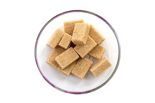 Кубики цільного тростинного цукру в тарілці, вид зверху, ізольовані на білому тлі — стокове фото