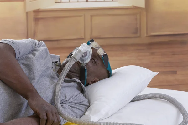 Gesundheitskonzept, afrikanisch, amerikanisch Mann mit obstruktiver Schlafapnoe schlafend gut mit cpap Maschine, Mann im Bett liegend mit cpap Maske, auf weißem Hintergrund — Stockfoto