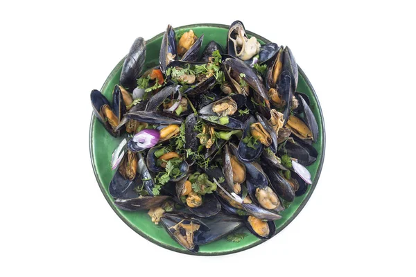 Moules cuites à la vapeur dans du vin blanc aux herbes, fruits de mer. Servi dans une assiette verte, vue vers le haut sur fond blanc — Photo