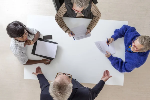 Två äldre kvinnor med sin advokat, tecken disposition för hans död och kommer, heritage testamentet dokumentet i en advokat notarie office på vit bakgrund — Stockfoto