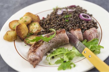 Fransa Toulouse ızgara sosis kavrulmuş potatoaes ve salata ve mercimek beyaz arka plan üzerinde