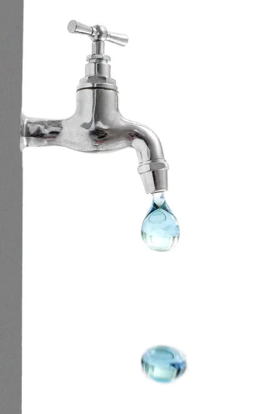 Vertical image of a drop of water falling from a tap, with another on the ground, on a white background. Space for text on the right space. — Stock Photo, Image