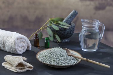 Siyah ahşap zemin üzerine Spa kompozisyon. Beyaz rulo havlu, pul pul dökülme eldiven, yağmur eldiven, okaliptüs, yeşil, kil maskesi yüz ve vücut için,