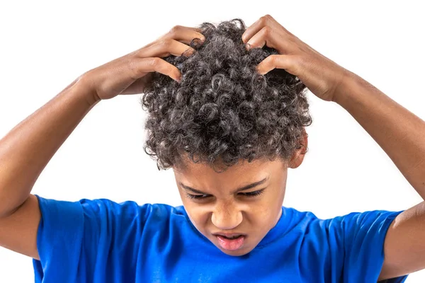 Sad young boy scratching hair for head lice or allergies — Stock Photo, Image