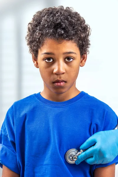 Arzt verwendet ein Stethoskop, um einem pädiatrischen Patienten Herztöne auf weiß auszukultivieren — Stockfoto