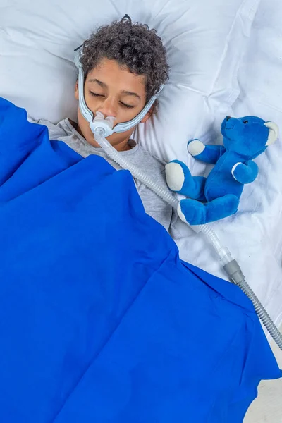 Child suffering from Sleep Apnea, wearing a respiratory mask. — Stock Photo, Image