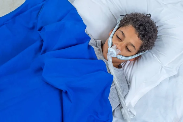 Enfant souffrant d'apnée du sommeil, portant un masque respiratoire . — Photo