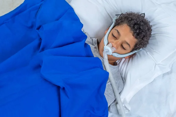 Bambino affetto da apnea del sonno, indossa una maschera respiratoria . — Foto Stock