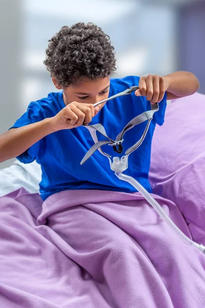 Niño que sufre de apnea del sueño, con una máscara respiratoria . — Foto de Stock