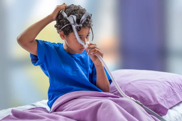 Criança que sofre de apneia do sono, usando uma máscara respiratória . — Fotografia de Stock