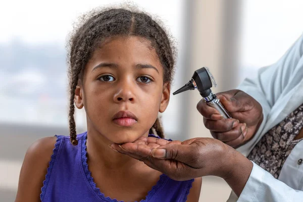 Ein Arzt untersucht mit einem Otoskop das Ohr des Patienten, ein Kind leidet an Ohrenschmerzen im Krankenhaus — Stockfoto