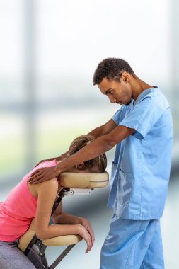 Fizyoterapist, klinikteki bir hastaya masaj yapıyor.