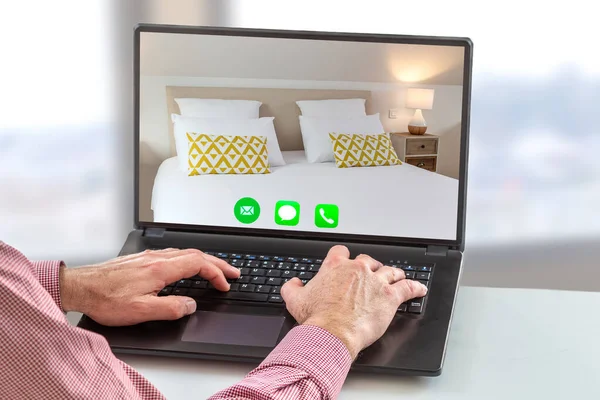 Concepto de reserva de vacaciones: la mano de un hombre keybording con el icono de llamada aquí, teléfono, mensajería, y el dormitorio de hotel en vivo en la pantalla en blanco — Foto de Stock