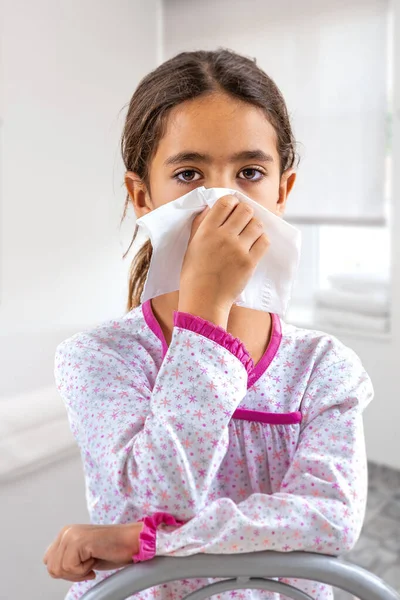 Niña linda estornudando en un pañuelo sonándose la nariz. tener gripe — Foto de Stock