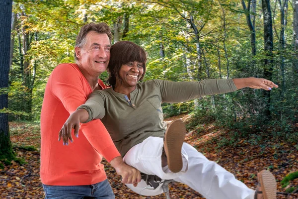 Activa de mediana edad Amar s pareja montar en bicicleta en el bosque.Happy pareja montar en bicicleta en el bosque . — Foto de Stock