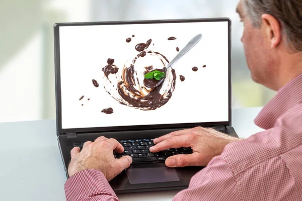 Назад взгляд человека, смотрящего блог видео о приготовлении шоколада на ноутбуке дома — стоковое фото