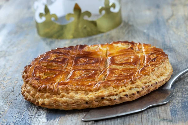 Epiphanie Douzième Gâteau de nuit Galette des rois française en pâte feuilletée, avec le charme à l'intérieur, couronne ouverte penchée sur le dessus — Photo