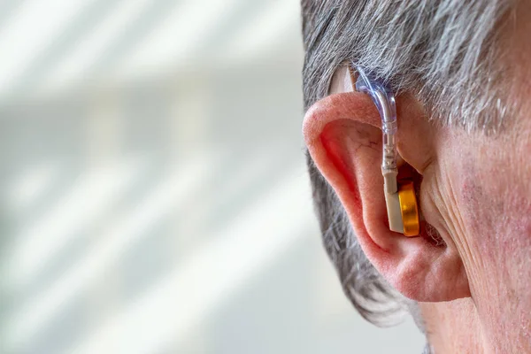 Chef för en äldre man med hörapparat i örat — Stockfoto