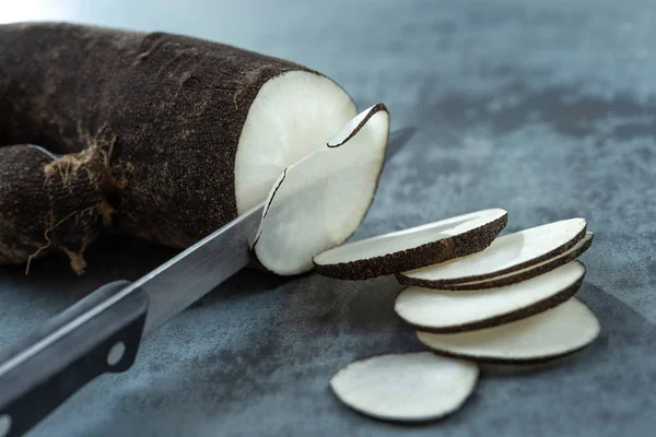 Three long black winter radishes Raphanus sativus subsp. niger and a cut one on a wooden background — 스톡 사진