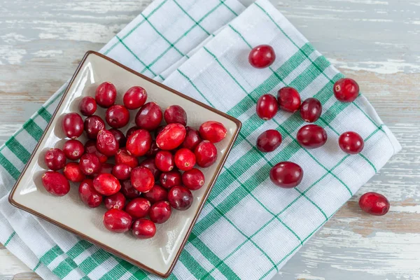 Fresh cranberries fruits in rustic asian bowl on old green wooden Background and daylight — Stockfoto