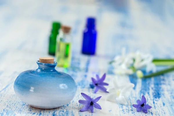 Komposition mit ätherischem Öl und Hyazinthenblüte in Glasflasche und Keramikflasche auf altem Holzgrund — Stockfoto