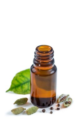 A bottle of cardamon essential oil with cardamon seeds and leaves on white clipart
