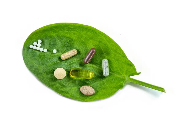 Homeopatia - Um conceito de homeopatia com medicina homeopática e suplemento alimentar em folhas verdes — Fotografia de Stock