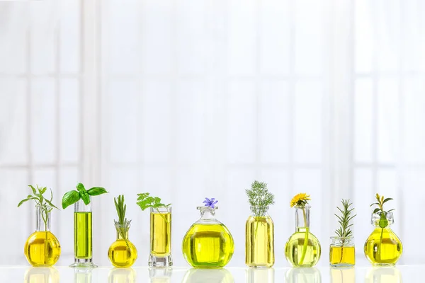 Botellas de aceite esencial de vidrio con hierbas en la parte superior sobre la mesa contra un viejo fondo interior —  Fotos de Stock