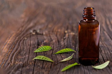 Limon verbena esaslı yağ bpttle ve ahşap tahtada yapraklar. Bardak, taze.