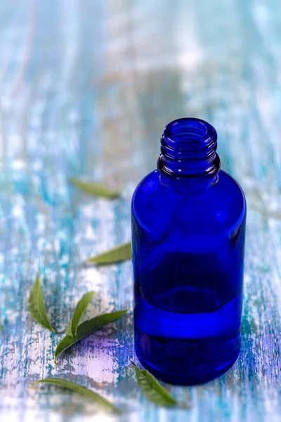 Citron Verbena eterisk olja och blad på trädens blå bräda. Glas, färskt — Stockfoto