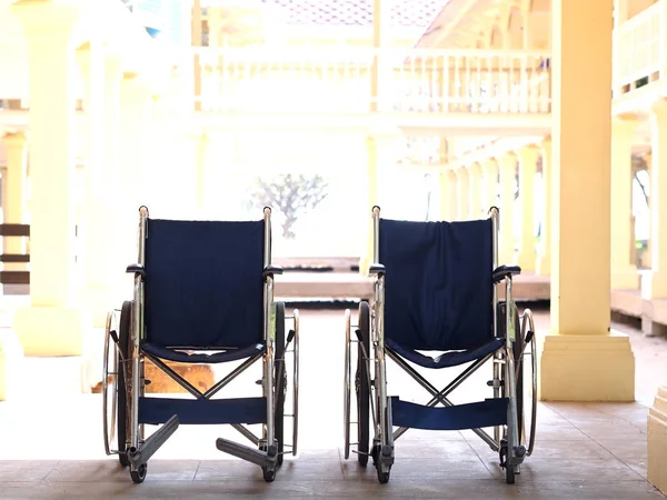 Lege twee standaard rolstoelen staan binnen op de middag. Stockfoto