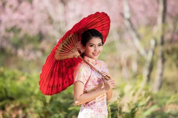 Çinli kadınlar geleneksel Cheongsam giyer..