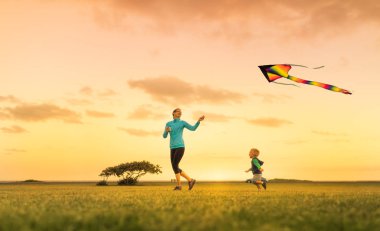 Anne ve oğul birlikte koşuyorlar uçurtma uçuruyorlar, dışarıda eğleniyorlar..