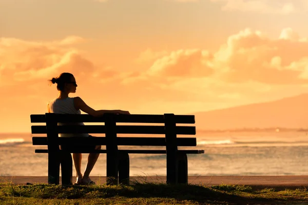 Προσεκτική Γυναίκα Που Κάθεται Στο Παγκάκι Κοιτάζοντας Ηλιοβασίλεμα Του Ωκεανού — Φωτογραφία Αρχείου
