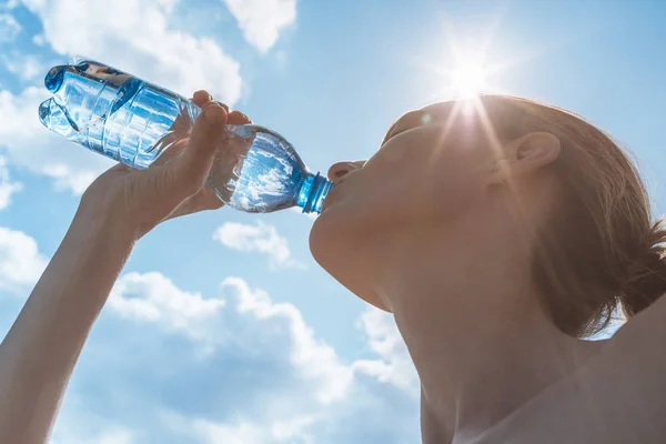 Female drinking bottle of water on a hot summer day. — Stock Photo, Image