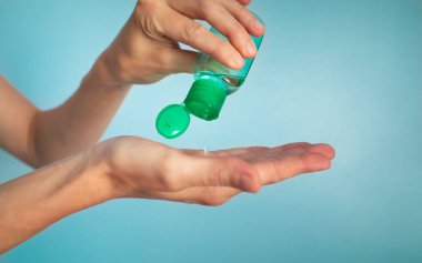 Kadın ellerini sıvı dezenfektan kullanarak temizliyor.. 