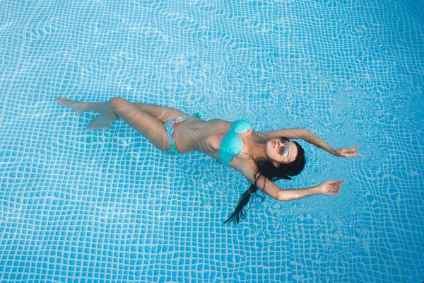 Modefoto von sexy schönen Mädchen mit brünetten Haaren im eleganten Bikini nimmt ein Sonnenbad im Schwimmbad — Stockfoto